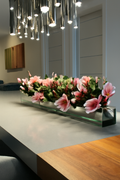 Cache-pot en verre avec magnolias rose vif et bois flotté