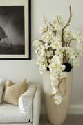 Cache-pot beige sable orchidées blanches retombantes